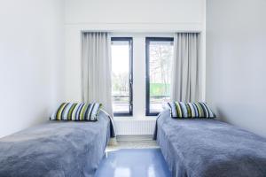 two beds in a room with a window at Forenom Hostel Vantaa Aviapolis in Vantaa