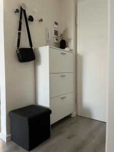 a white cabinet with a black ottoman in a room at Garden Lake Apartment in Peschiera del Garda