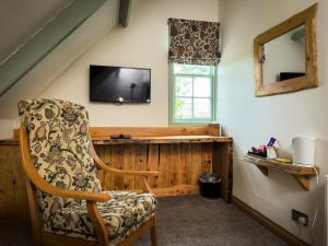 a living room with a chair and a television at Borgie Lodge Hotel in Borgie