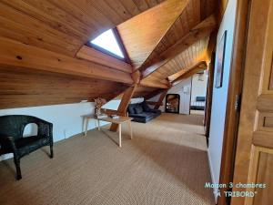 une chambre mansardée avec un plafond en bois et une lucarne dans l'établissement À la vie, à la mer., à Sangatte
