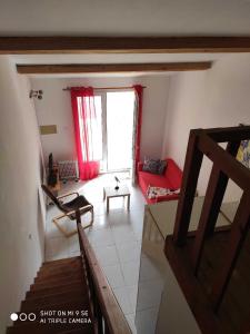 - une vue aérienne sur le salon doté d'un canapé rouge dans l'établissement A quelques pas de la mer, à Saint Cyprien Plage 1 autre photo