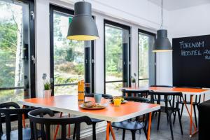 a restaurant with tables and chairs and windows at Forenom Hostel Vantaa Aviapolis in Vantaa