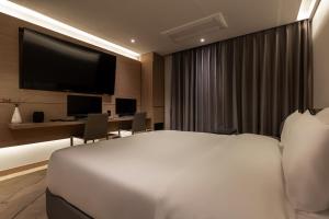 Una habitación de hotel con una cama, un escritorio y un televisor. en 21 Heritage Hotel, en Wonju 15 fotos más