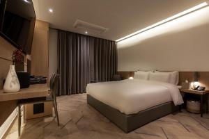 Una habitación de hotel con una cama grande y un escritorio. en 21 Heritage Hotel, en Wonju