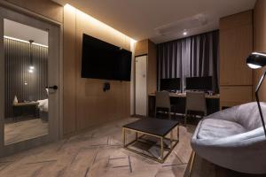 Una sala de estar con un sofá, un televisor y una mesa. en 21 Heritage Hotel, en Wonju