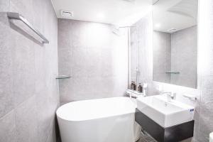Un baño con un inodoro blanco y un lavabo. en On the Moon Hotel, en Wonju