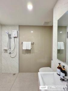 a bathroom with a shower and a sink and a toilet at อีสต์วิลล์บางแสน36 in Ban Hua Khao Sammuk +3 photos