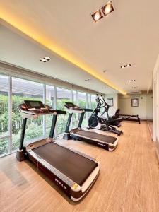 a gym with several treadmills and exercise bikes at อีสต์วิลล์บางแสน36 in Ban Hua Khao Sammuk
