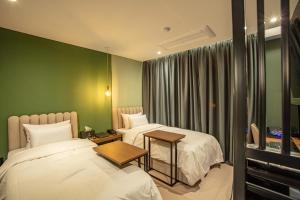 Dos camas en una habitación con paredes verdes. en On the Moon Hotel, en Wonju