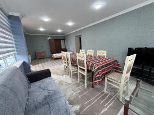 a dining room with a table and chairs and a couch at Qoşa bulaq in Avaxıl