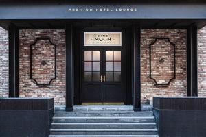 una puerta a un edificio de ladrillo con un cartel en él en On the Moon Hotel, en Wonju