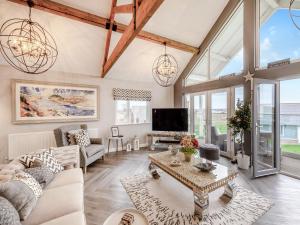 ein Wohnzimmer mit weißen Möbeln und großen Fenstern in der Unterkunft Stargazer in Beadnell