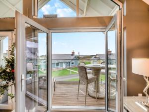 eine abgeschirmte Veranda mit einem Tisch und einem Stuhl auf dem Balkon in der Unterkunft Stargazer in Beadnell