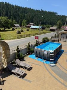 a swimming pool with two lounge chairs and a swimming pool at "Як вдома" Буковель in Bukovel