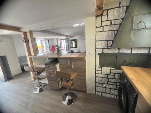 a kitchen with two chairs and a stone wall at Appartement duplex en Alsace in Geudertheim