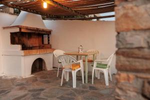 a patio with a table and chairs and a fireplace at Aurea Blu studio 17, Sea view, tranquility, relaxation, sun in Aliko Beach
