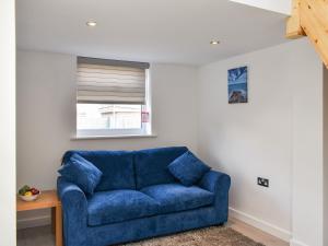 ein blaues Sofa im Wohnzimmer mit Fenster in der Unterkunft The Boat House in Padstow