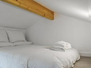 ein Schlafzimmer mit einem Bett mit weißen Laken in der Unterkunft The Boat House in Padstow