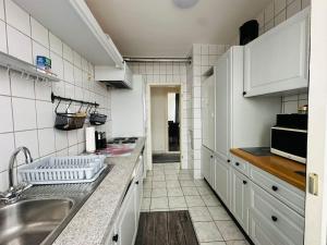 a kitchen with white cabinets and a sink at Cocoon City in Stuttgart