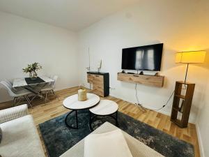 a living room with a table and a tv on a wall at Cocoon City in Stuttgart