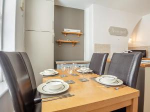 a dining room table with chairs and a table with wine glasses at Rhiw Bank Apartment in Colwyn Bay