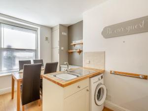 a laundry room with a sink and a table at Rhiw Bank Apartment in Colwyn Bay