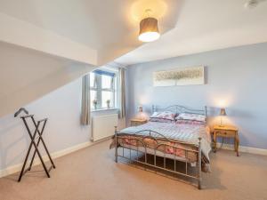 a bedroom with a bed and two tables and a window at Rhiw Bank Apartment in Colwyn Bay +7 photos