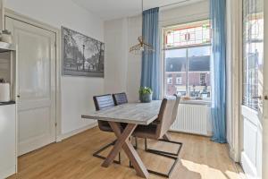a dining room with a wooden table and chairs and a window at Authentic stay in Alkmaar in Alkmaar