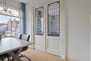 a dining room with a table and a door at Authentic stay in Alkmaar in Alkmaar