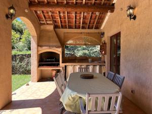 cocina con mesa y sillas en el patio en Beau mas cévenol avec piscine, en Corbés