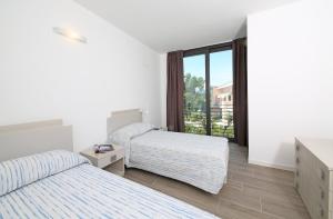 pokój hotelowy z dwoma łóżkami i oknem w obiekcie Villa T14 w mieście Bardolino