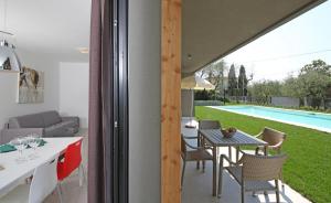patio ze stołem i krzesłami oraz basenem w obiekcie Villa T14 w mieście Bardolino