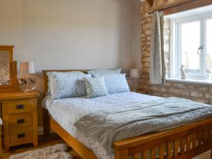 a bedroom with a bed with blue pillows and a window at The Dairy - Uk48756 in Bempton +13 photos