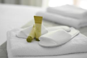 ein Stapel weißer Handtücher mit einer Zahnbürste und Zahnpasta in der Unterkunft Hotel Argilos in Asprovalta + 77 Fotos