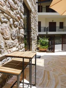 a wooden bench sitting next to a stone building at Olympus Stone Lodge in Litochoro