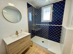 ein Badezimmer mit Dusche, Waschbecken und Spiegel in der Unterkunft Évasion Marine à 2 pas du Port in Saint-Gilles-Croix-de-Vie