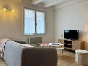 ein Wohnzimmer mit Sofa und Fernseher in der Unterkunft Évasion Marine à 2 pas du Port in Saint-Gilles-Croix-de-Vie