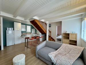 ein Wohnzimmer mit Sofa und eine Küche in der Unterkunft Évasion Marine à 2 pas du Port in Saint-Gilles-Croix-de-Vie