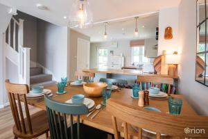 Una cocina y un comedor con mesa y sillas de madera. en Isis Lakes 31, Bonheur, en South Cerney 21 fotos más