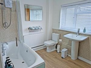 ein Badezimmer mit Badewanne, Toilette und Waschbecken in der Unterkunft Trinity Cottage in Abergavenny