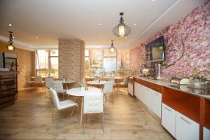 eine Küche mit einem Esszimmer mit Tischen und Stühlen in der Unterkunft Rio Boutique Hotel Vlore in Vlorë