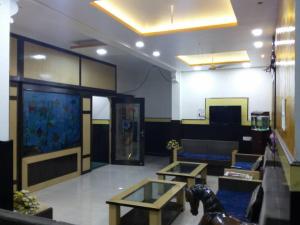 a living room with two tables and a large aquarium at Hotel Kanha International in Dhār