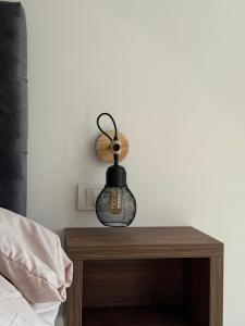 a lamp on a table next to a bed at Noa Apartments Pool & Spa in Kragujevac