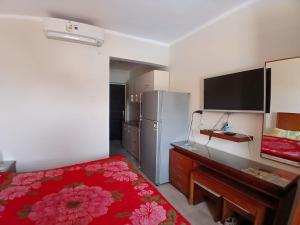 ein Schlafzimmer mit einem Bett, einem Schreibtisch und einem Kühlschrank in der Unterkunft Aqua view Park North coast ---91km in El-Alamein