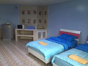 a bedroom with two beds and a counter with a microwave at Smart Residence@Muengthongthani in Nonthaburi