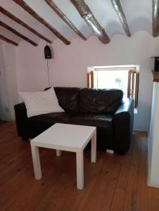 un soggiorno con divano in pelle nera e tavolo bianco di Casa del lince a Inazares