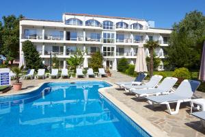a hotel with a pool and chairs and a building at Complex Moskoyani in Nesebar