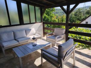 a living room with a couch and a table and chairs at Vikendica Nina in Bor