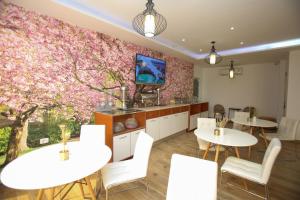 ein Restaurant mit zwei Tischen und einem Baum mit rosa Blüten in der Unterkunft Rio Boutique Hotel Vlore in Vlorë