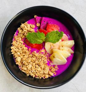 a bowl of granola and fruit on a pink plate at Medori Putih Homestay in Uluwatu +174 photos